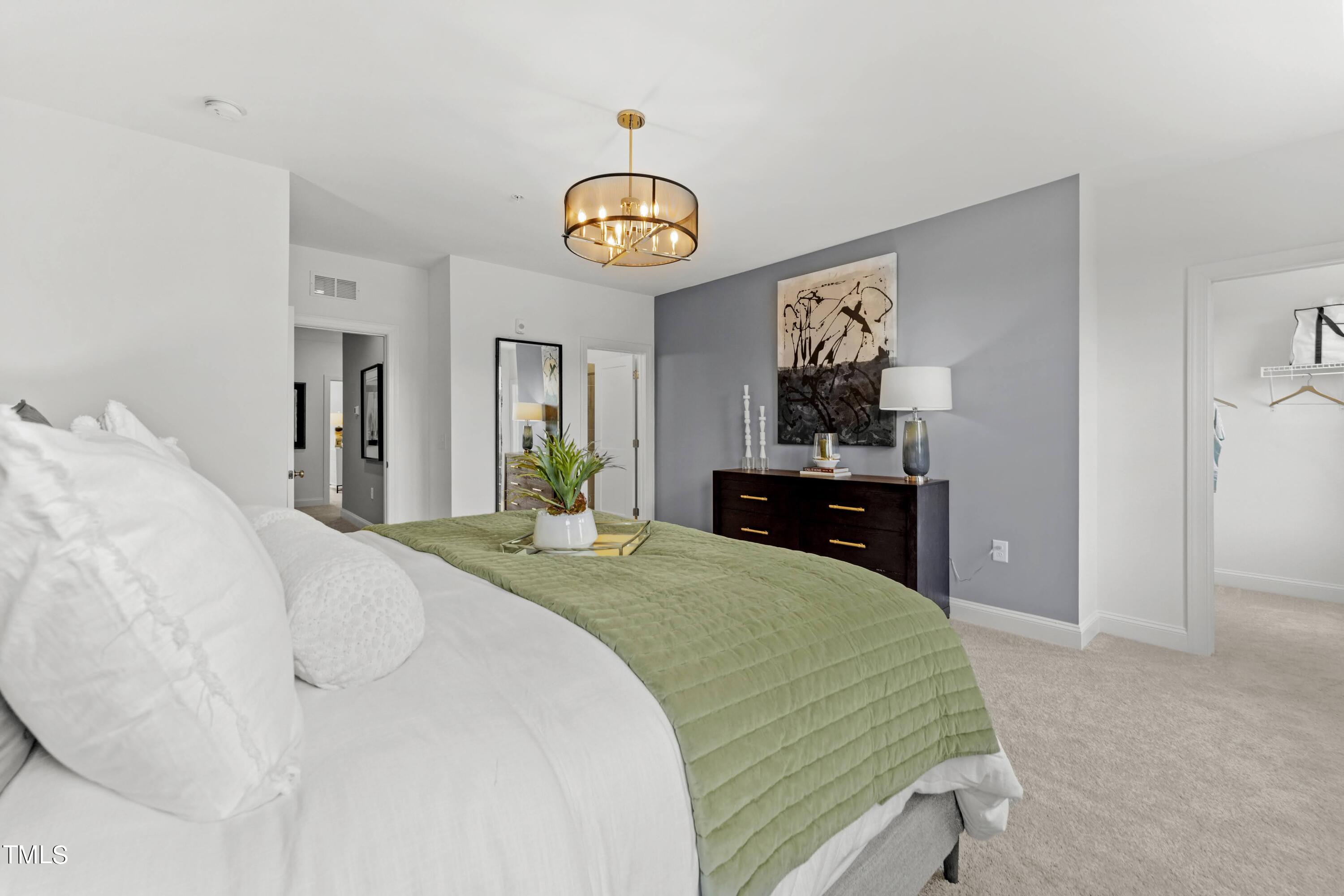 a bedroom with a bed and a chandelier