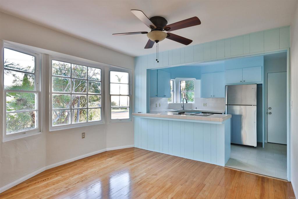 a kitchen with stainless steel appliances granite countertop a sink cabinets wooden floor and a window