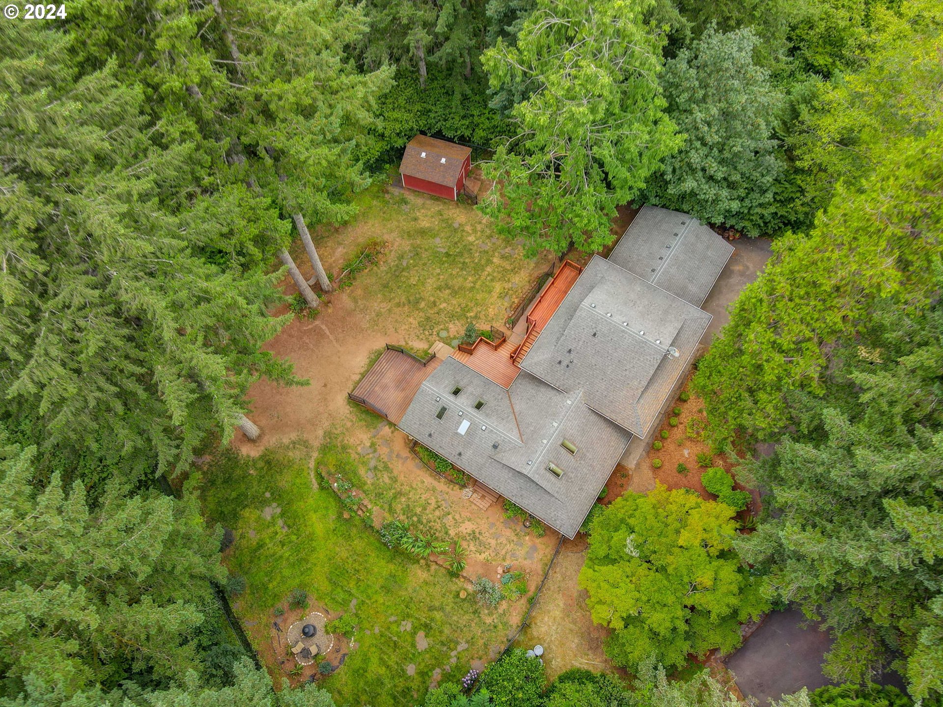 an aerial view of a house with a yard and large trees