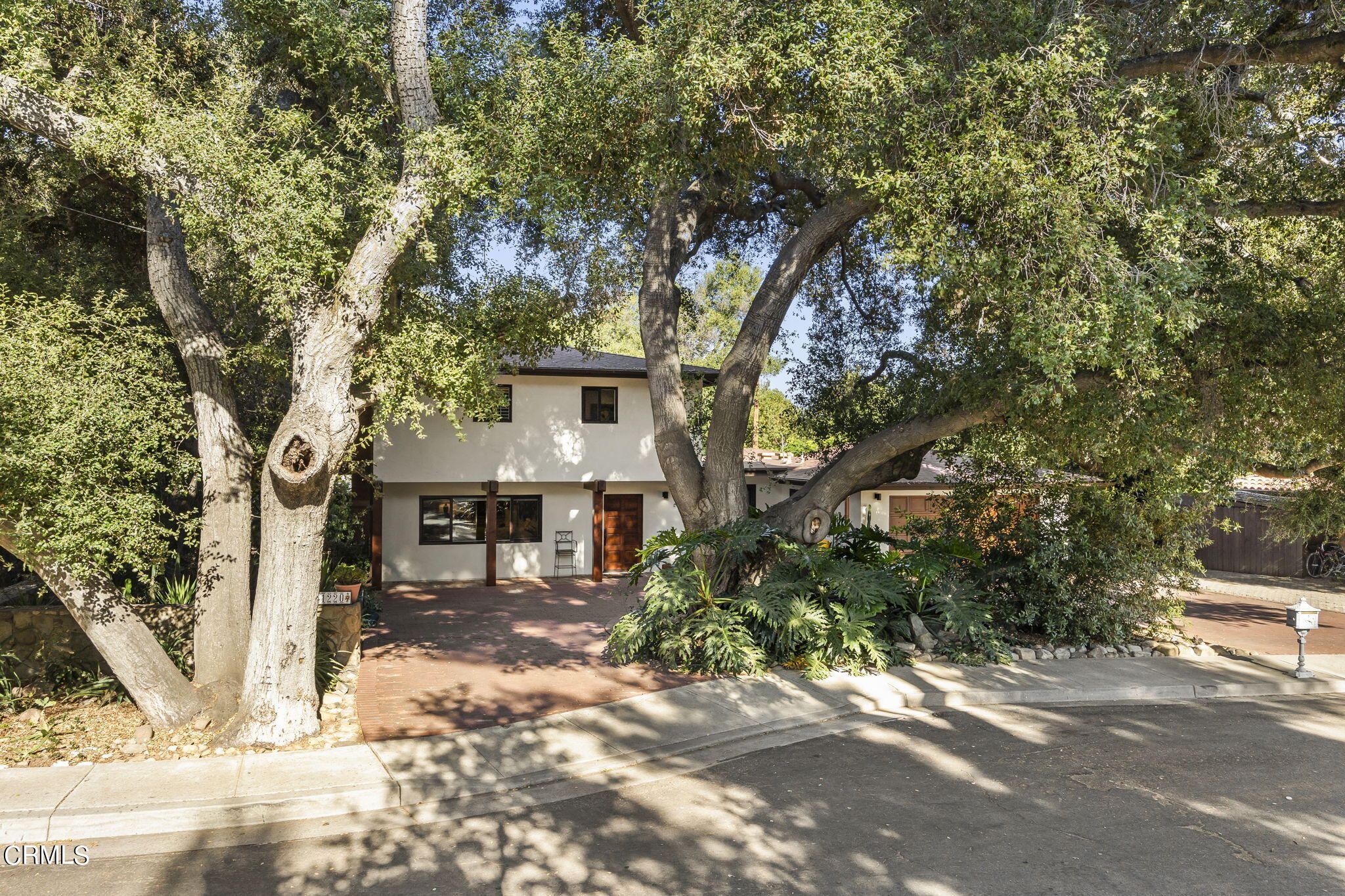 a front view of a house with a tree