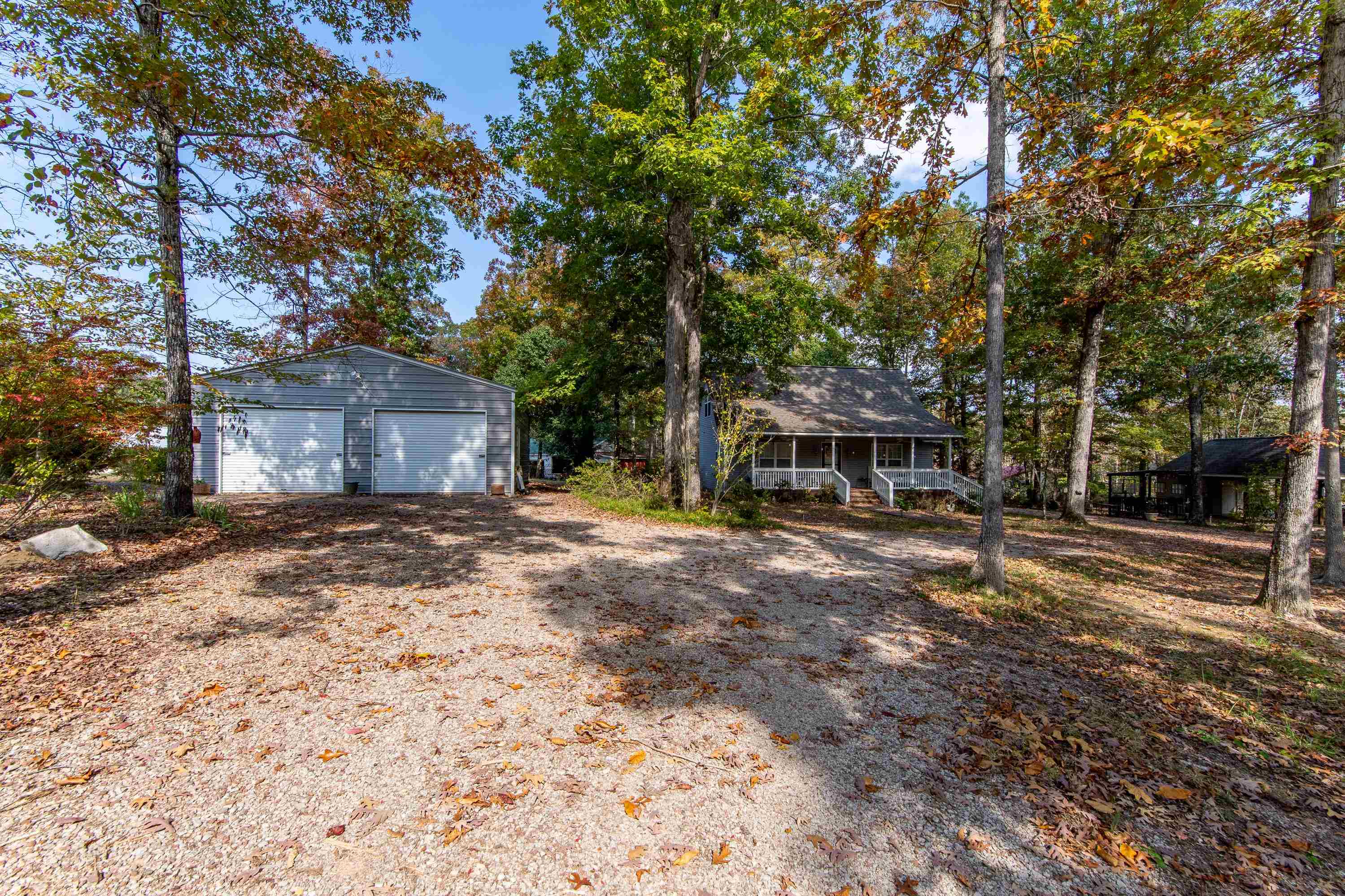 a front view of a house with a yard and large trees