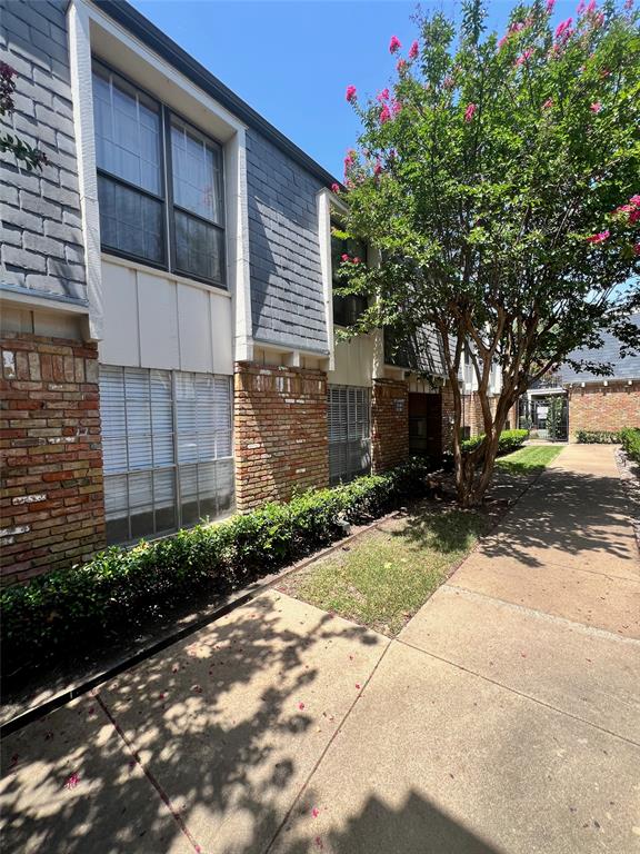 a view of a brick house with a yard