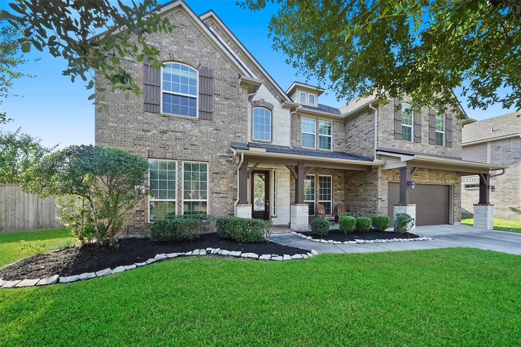 a front view of a house with a yard and green space