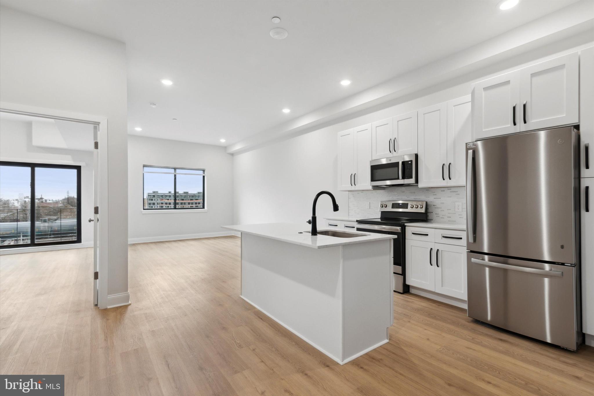 a kitchen with a refrigerator cabinets and wooden floor