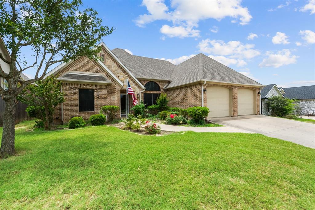 a front view of a house with a garden and yard