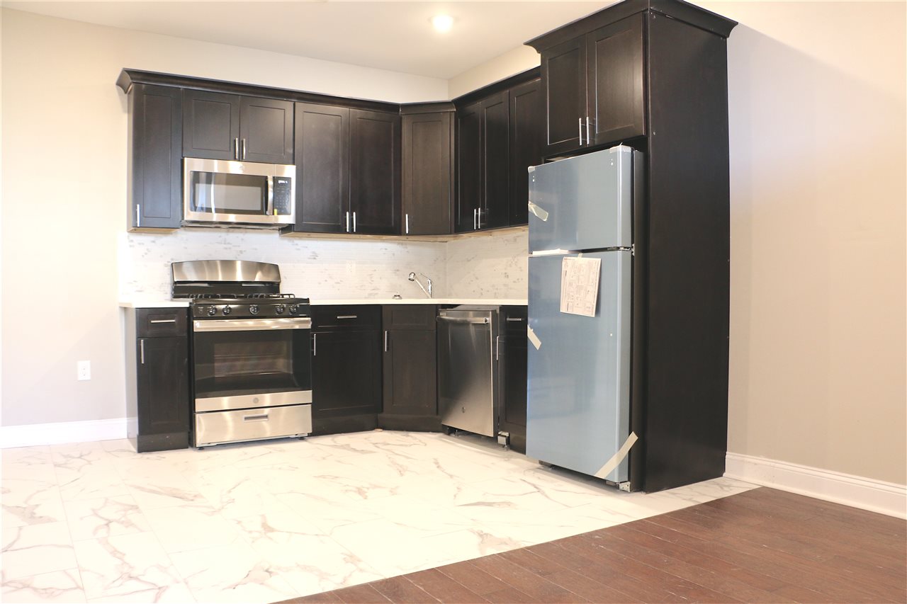 a kitchen with stainless steel appliances granite countertop a refrigerator and a stove