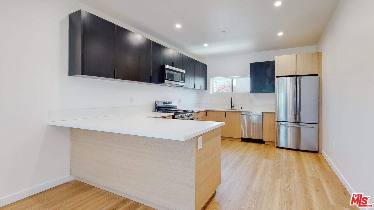 a kitchen with stainless steel appliances a refrigerator sink and microwave