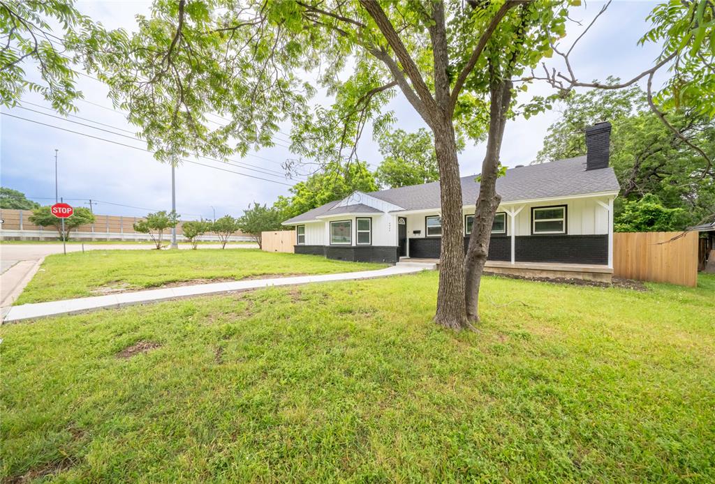 a view of a house with backyard and tree