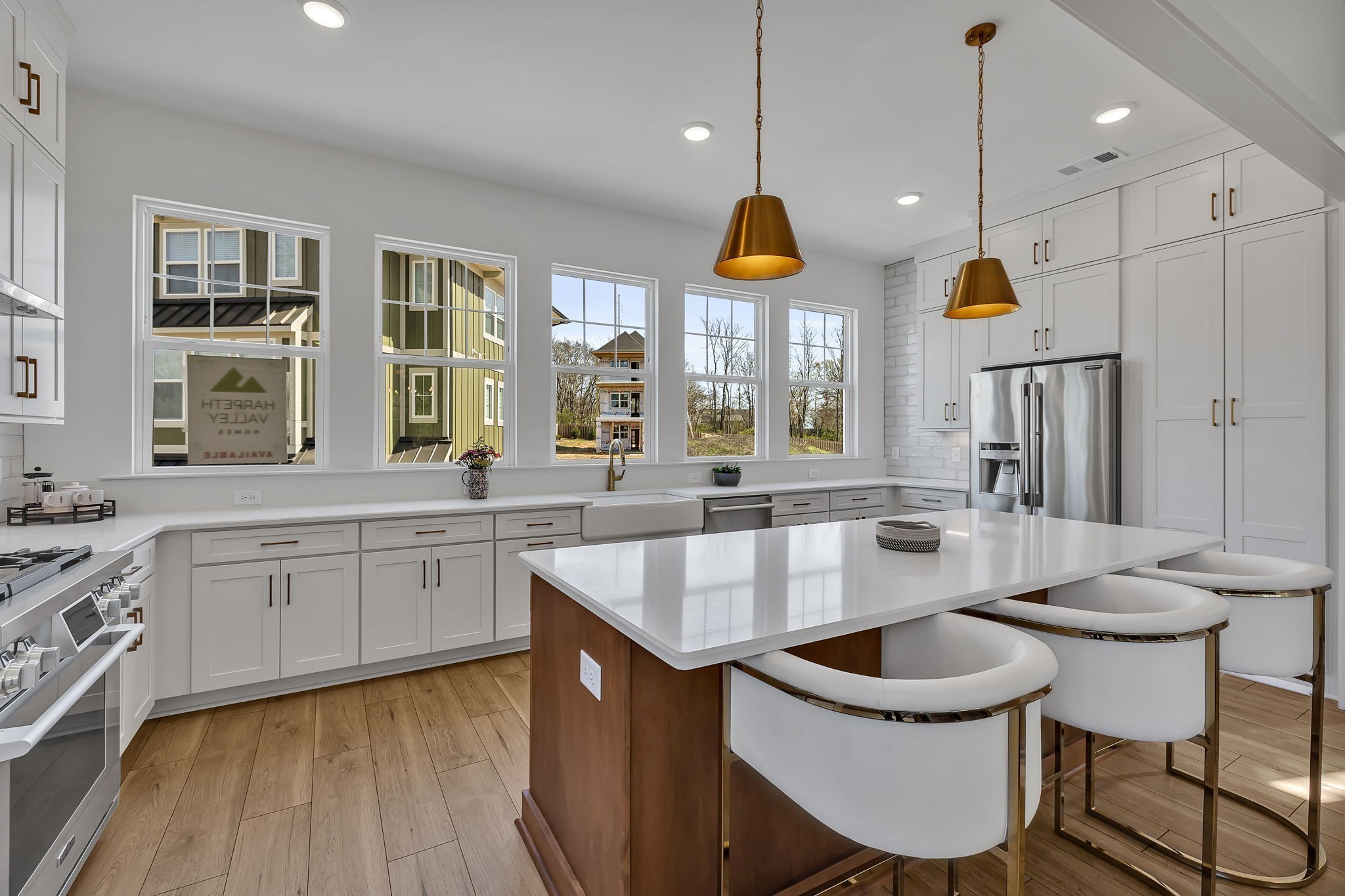 a kitchen with stainless steel appliances granite countertop a sink a stove and a wooden floors