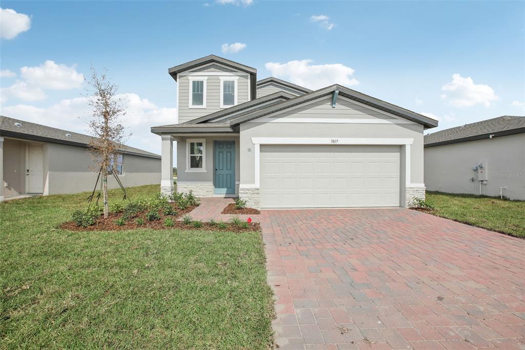 a front view of a house with a yard and garage