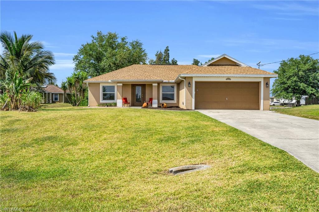 Ranch-style home featuring a front yard and a garage