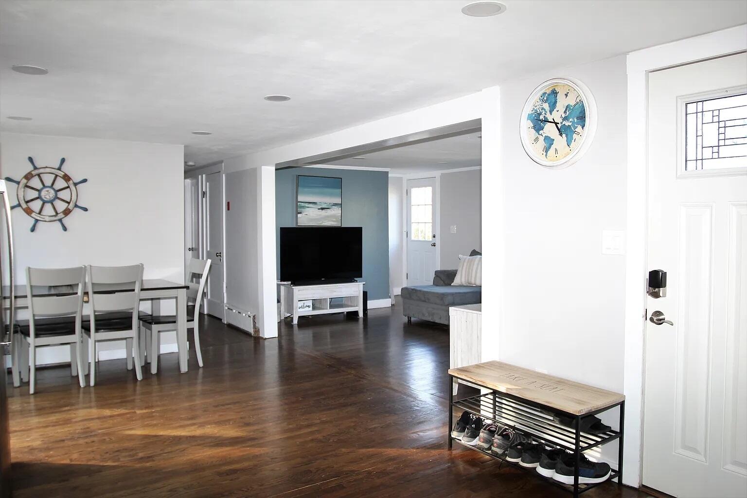 a living room with furniture a flat screen tv and kitchen view