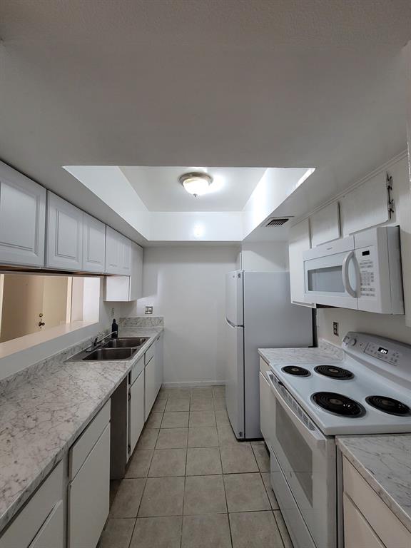 a kitchen that has a sink a stove and cabinets