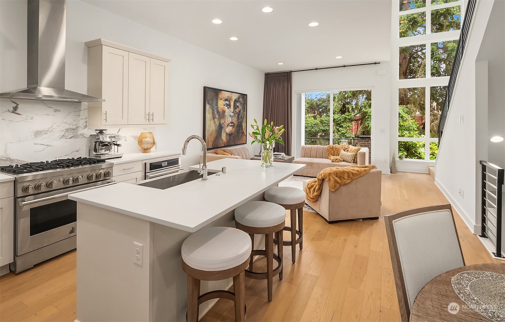 a kitchen with a stove a sink a kitchen island with a dining table and chairs