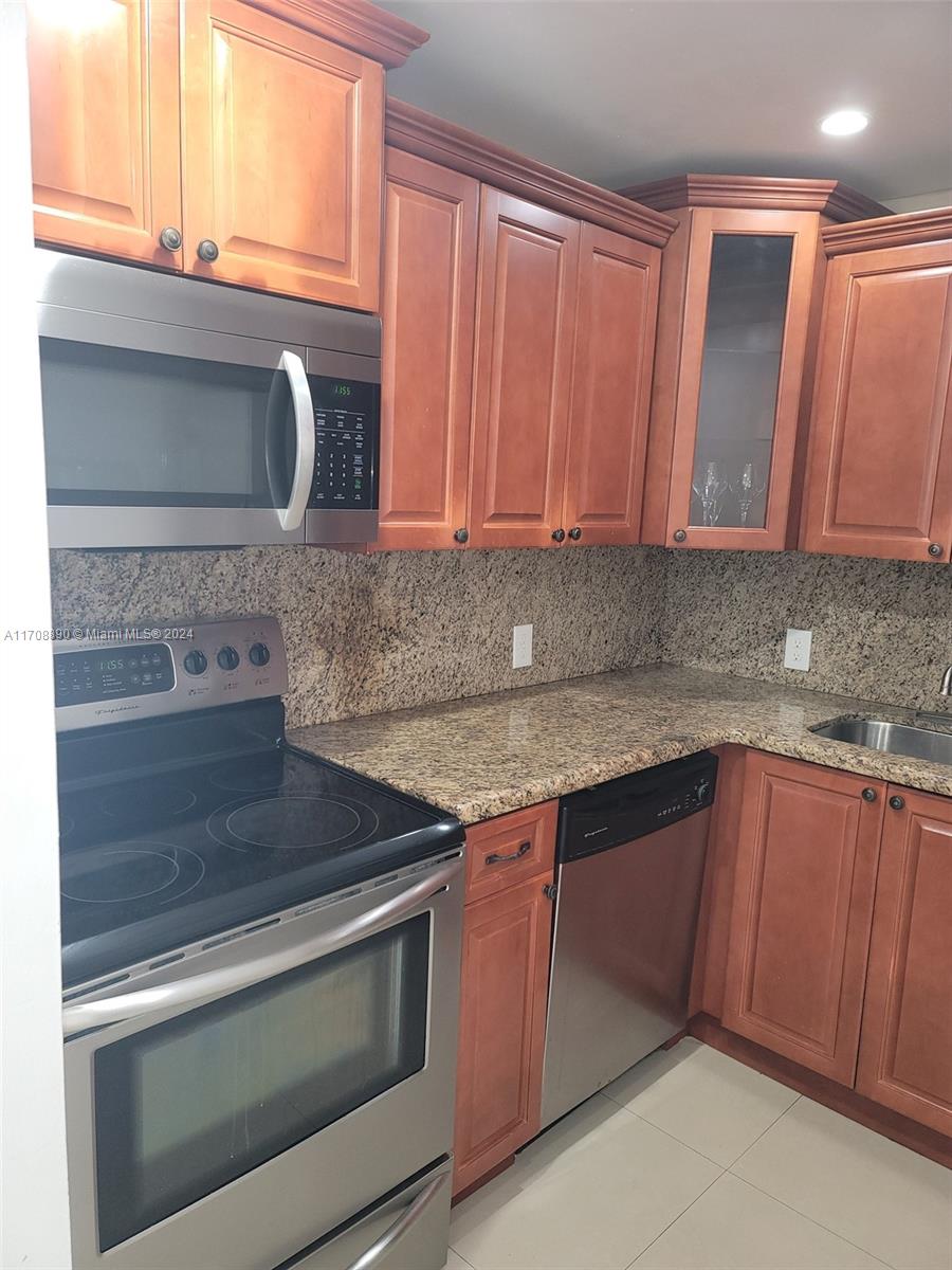 a kitchen with granite countertop cabinets stainless steel appliances and a sink