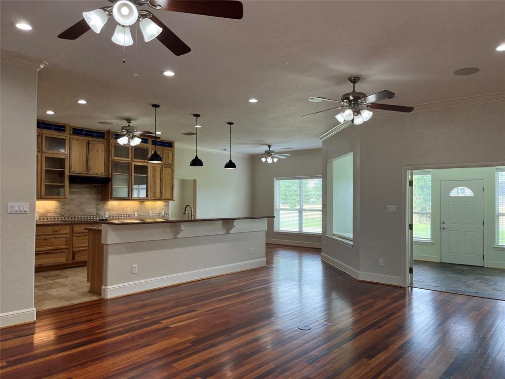 an open kitchen view with wooden floor and large windows