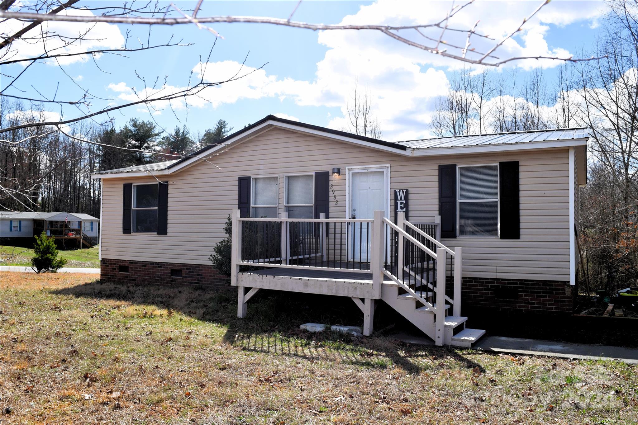 a view of a house with a yard chairs and wooden fence