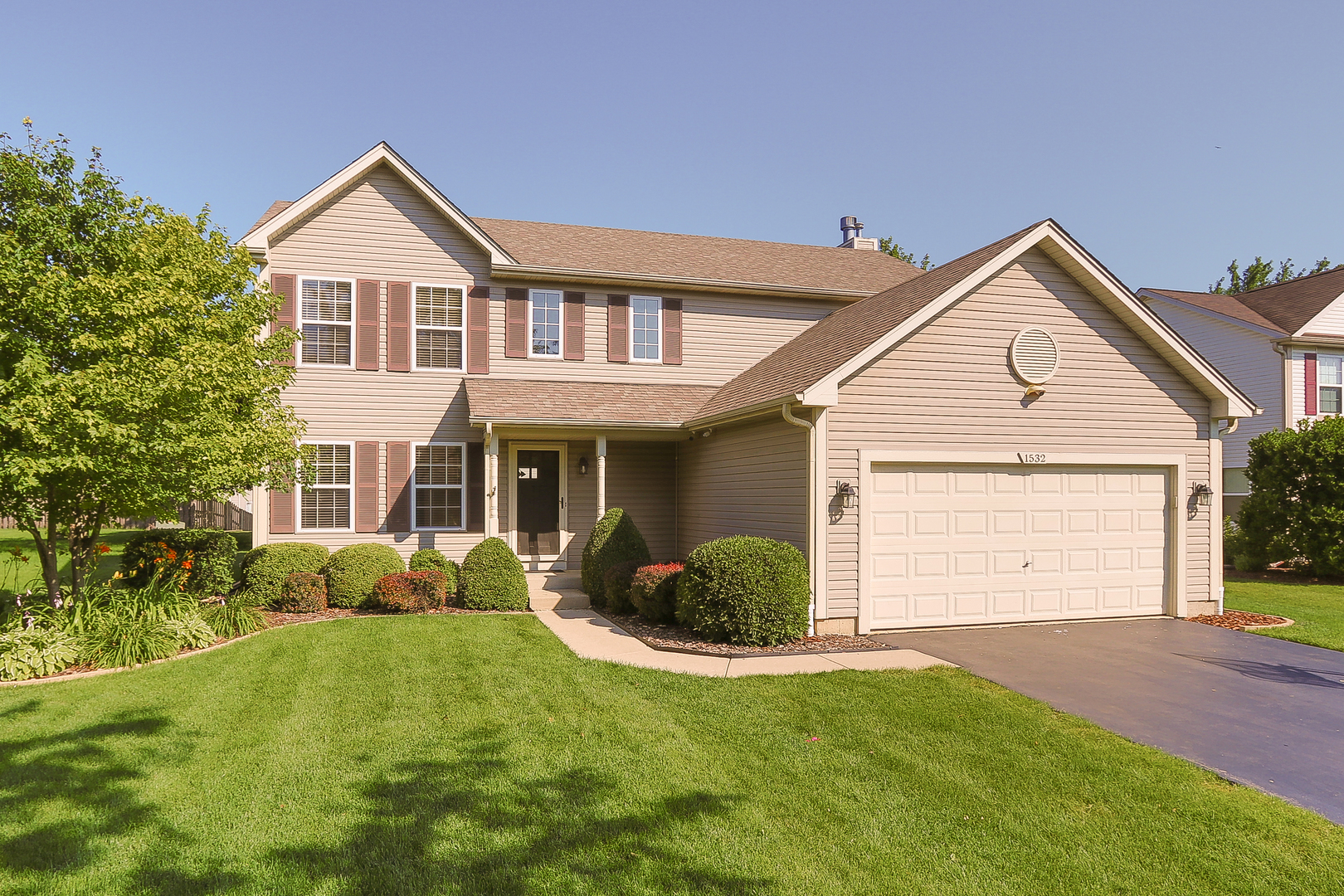 a front view of a house with a yard and garage