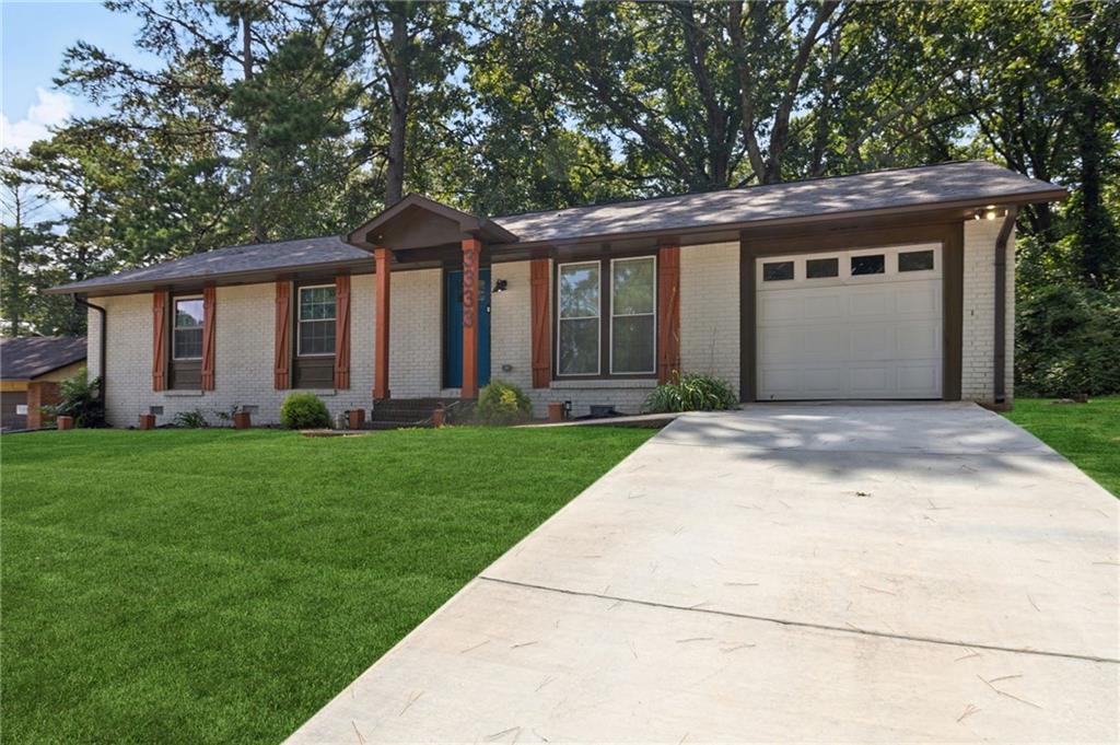 a front view of a house with a garden and yard