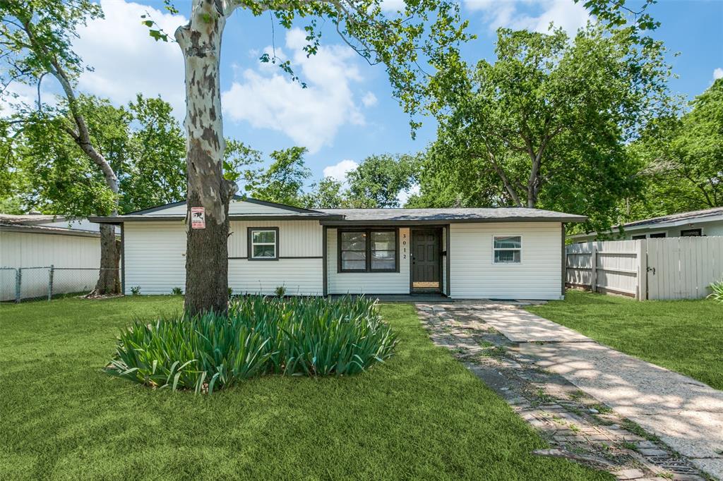 a view of a house with a yard and a large tree