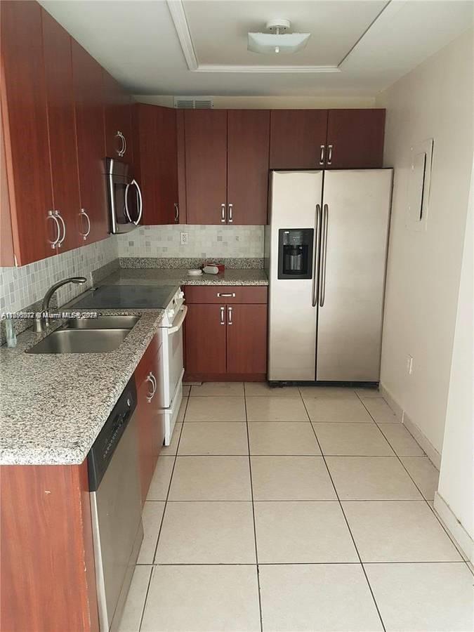 a kitchen with a sink a counter top space cabinets and stainless steel appliances