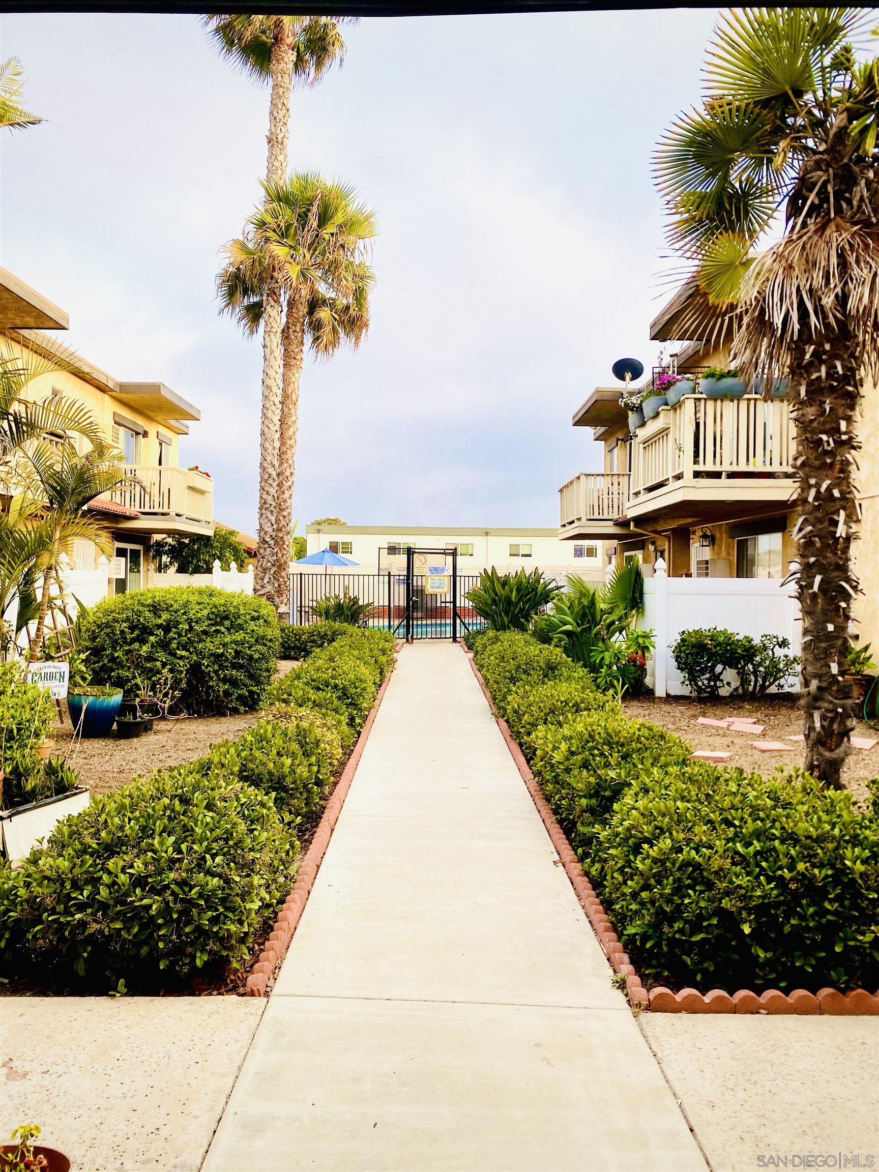 a front view of a house with a yard and potted plants