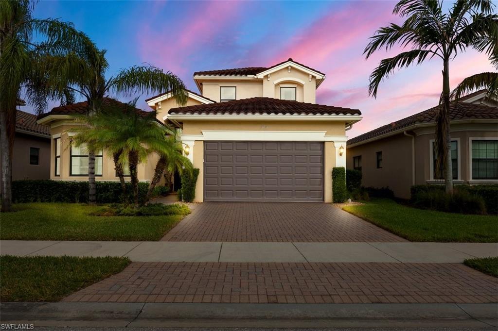 Mediterranean / spanish-style home with a lawn and a garage