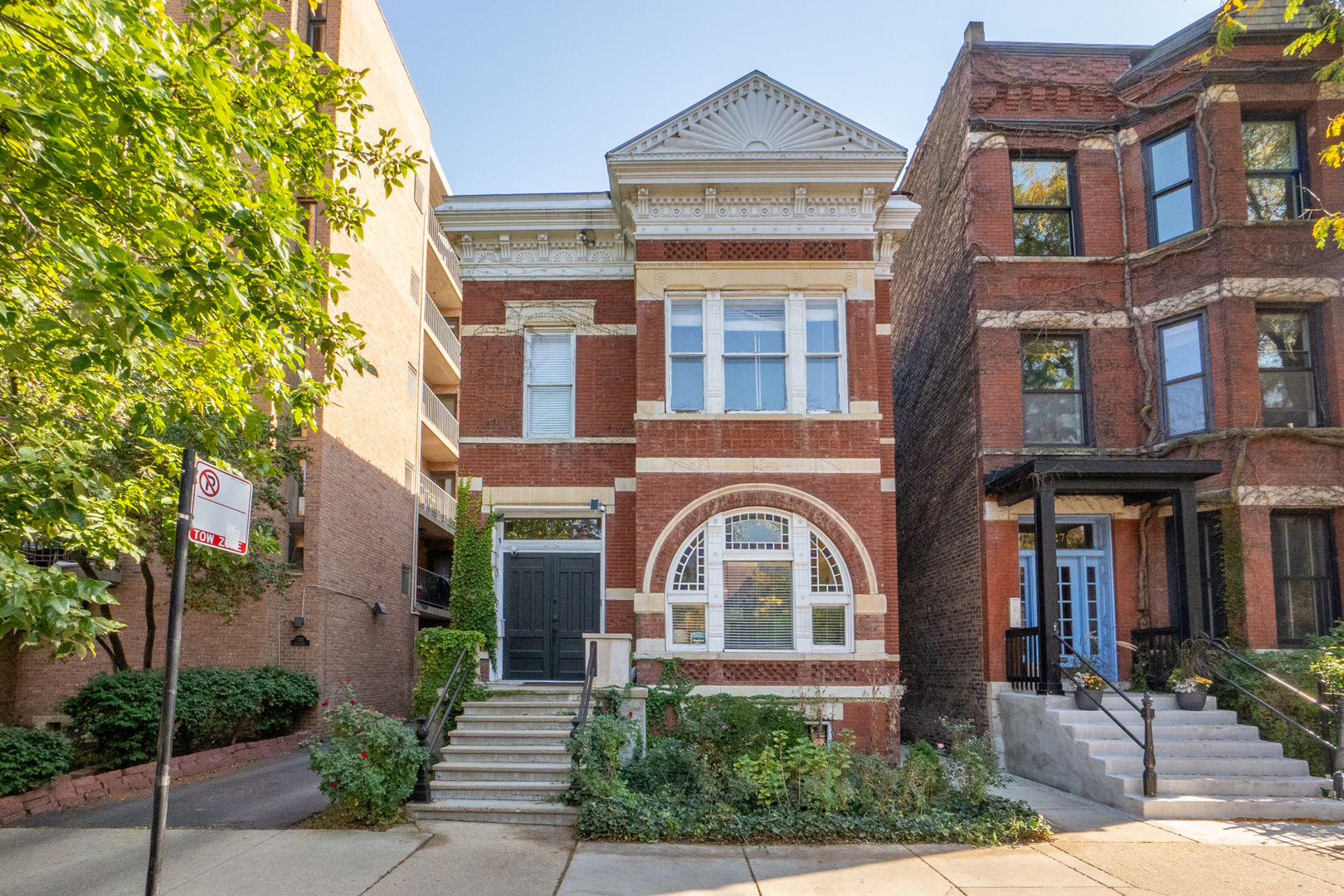 front view of a brick house with a small yard