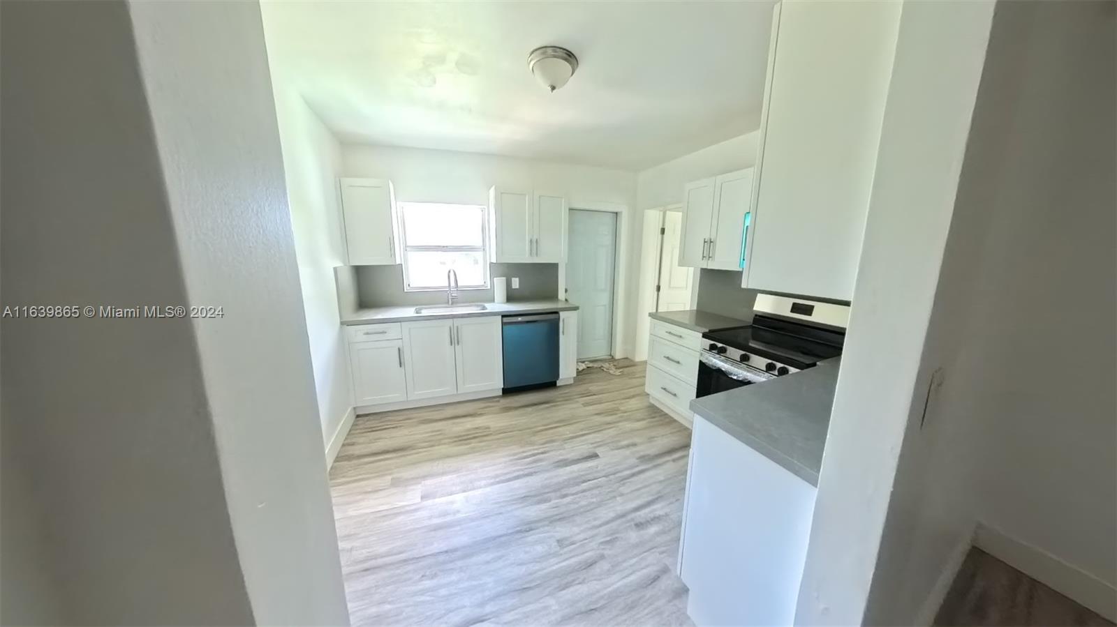 a kitchen with a refrigerator and a stove top oven