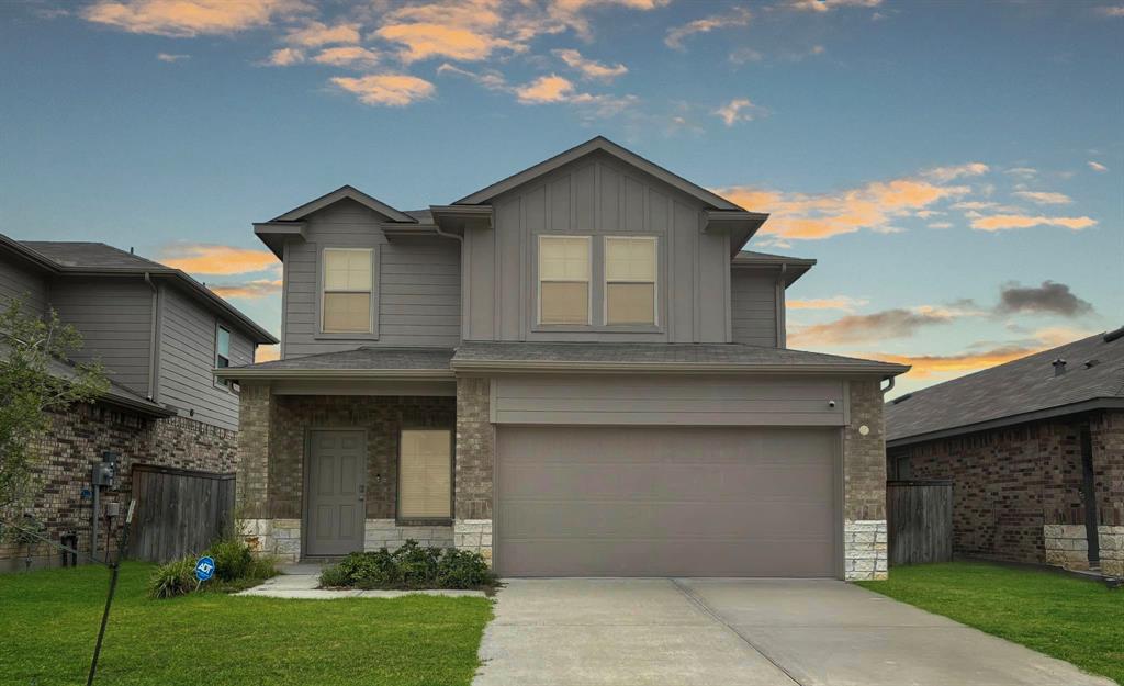 a front view of a house with a yard and garage