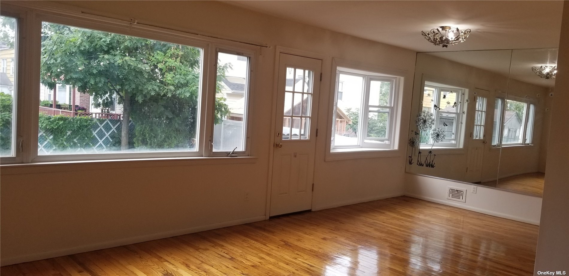 a view of an empty room with a window and a kitchen