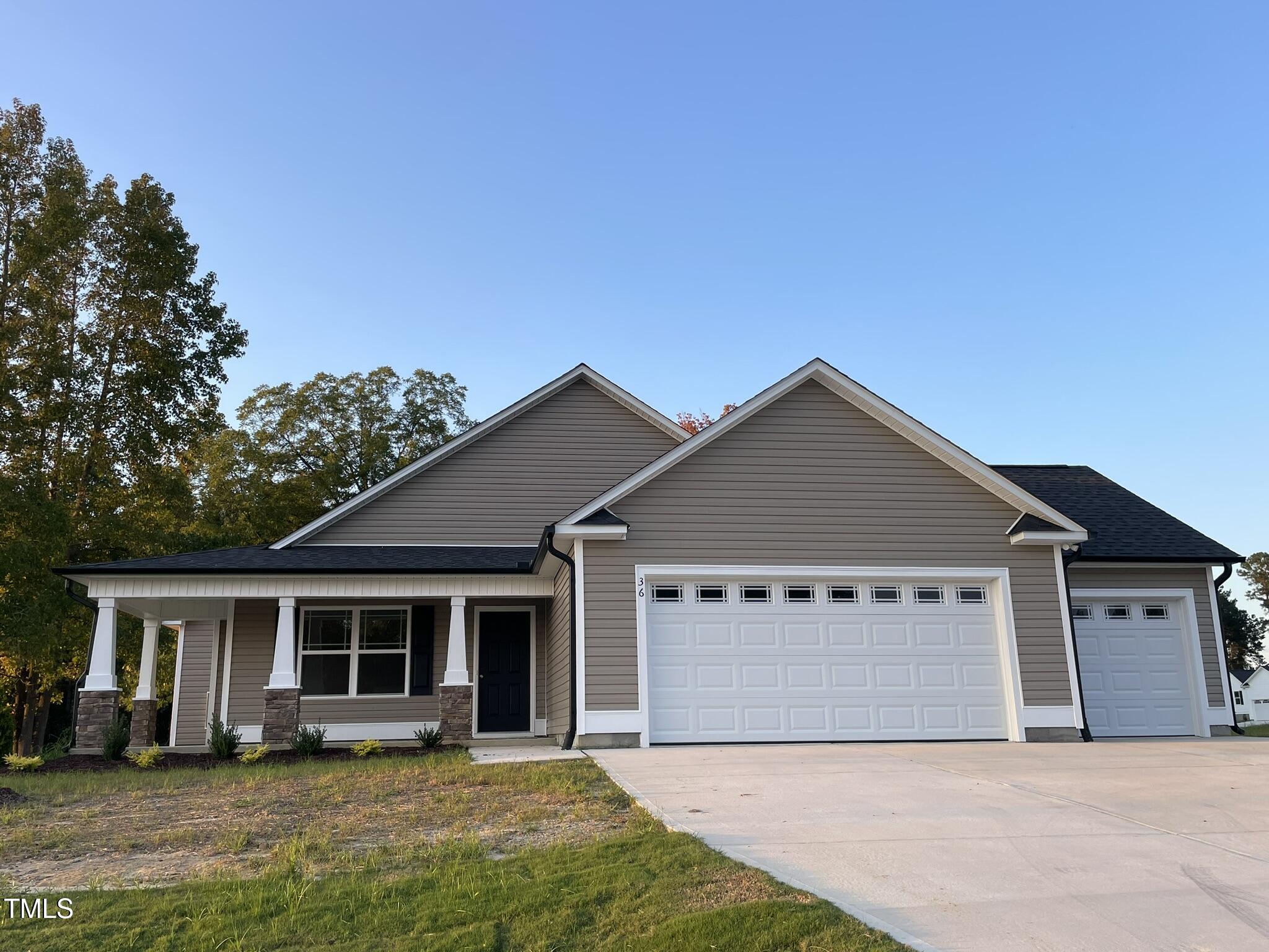 a front view of a house with yard and green space