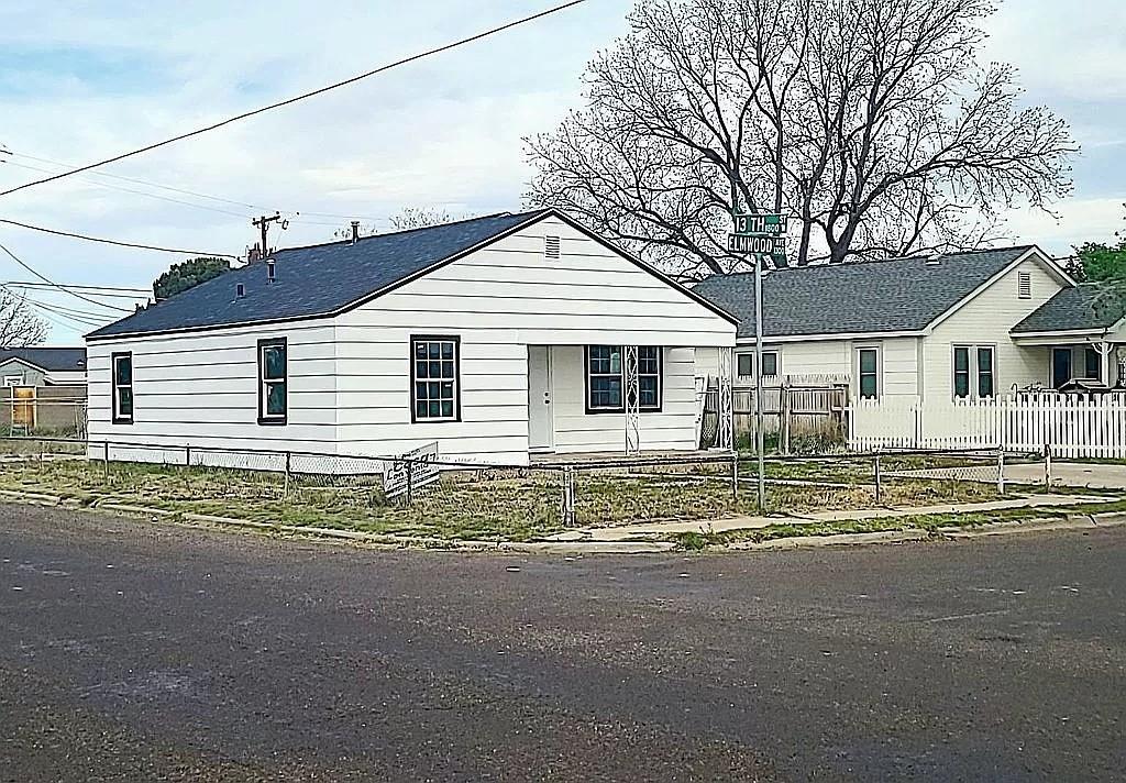 a view of a house with a large space and large tree