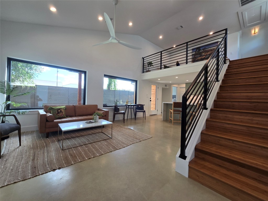 Huge open living room with lots of windows and an open loft looking out to the living space.