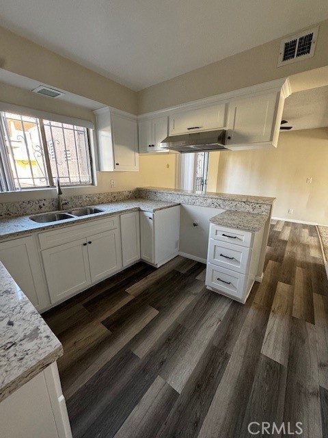 a kitchen with granite countertop a sink and cabinets