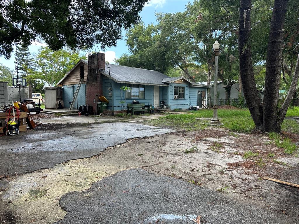 a view of a house with a yard and large trees