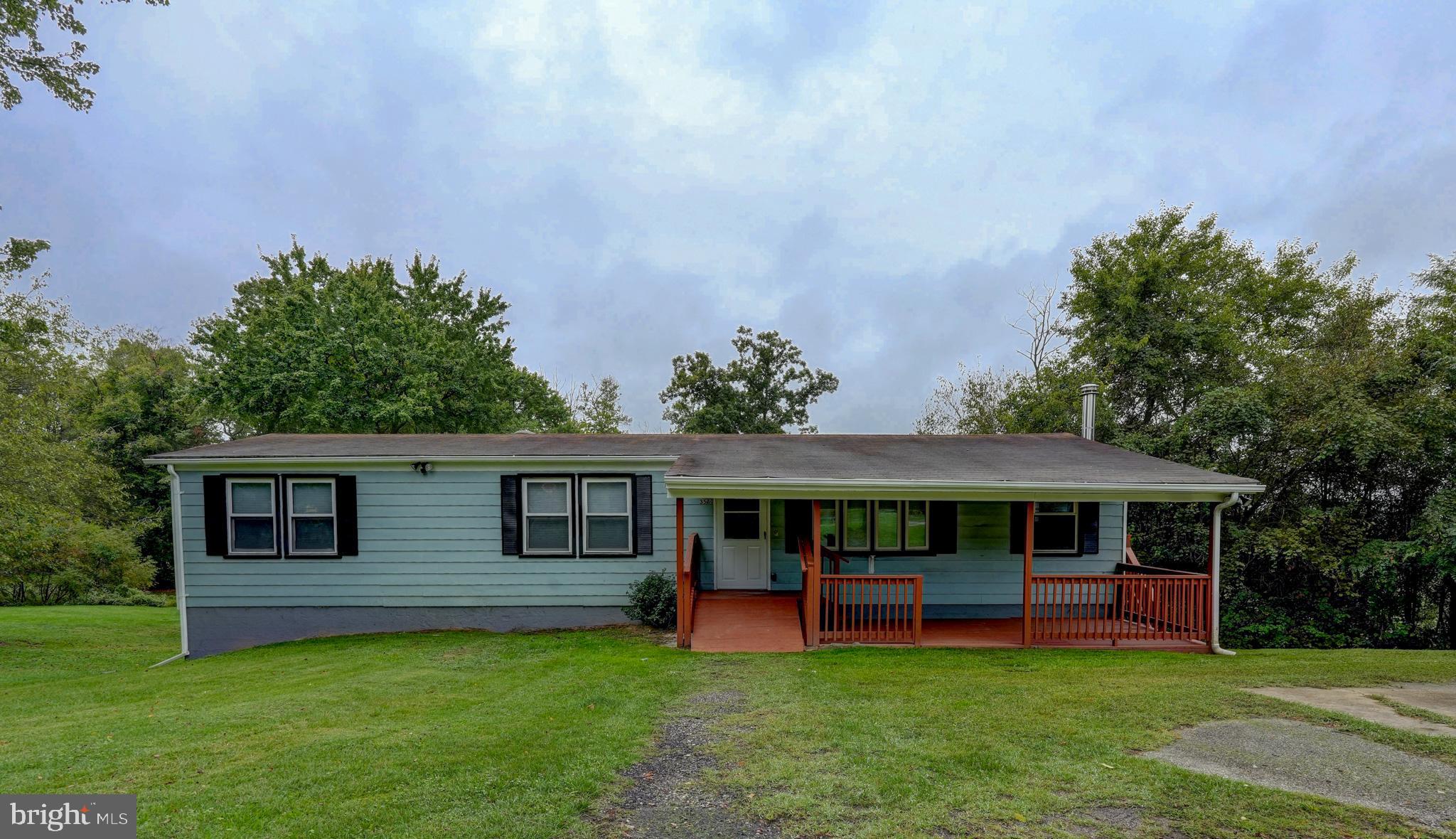 a view of a house with a yard and sitting area