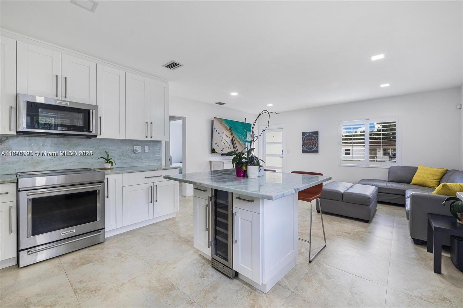 a kitchen with granite countertop a stove top oven a sink dishwasher and a fireplace with wooden floor