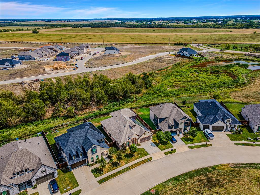 an aerial view of residential houses with outdoor space and ocean view