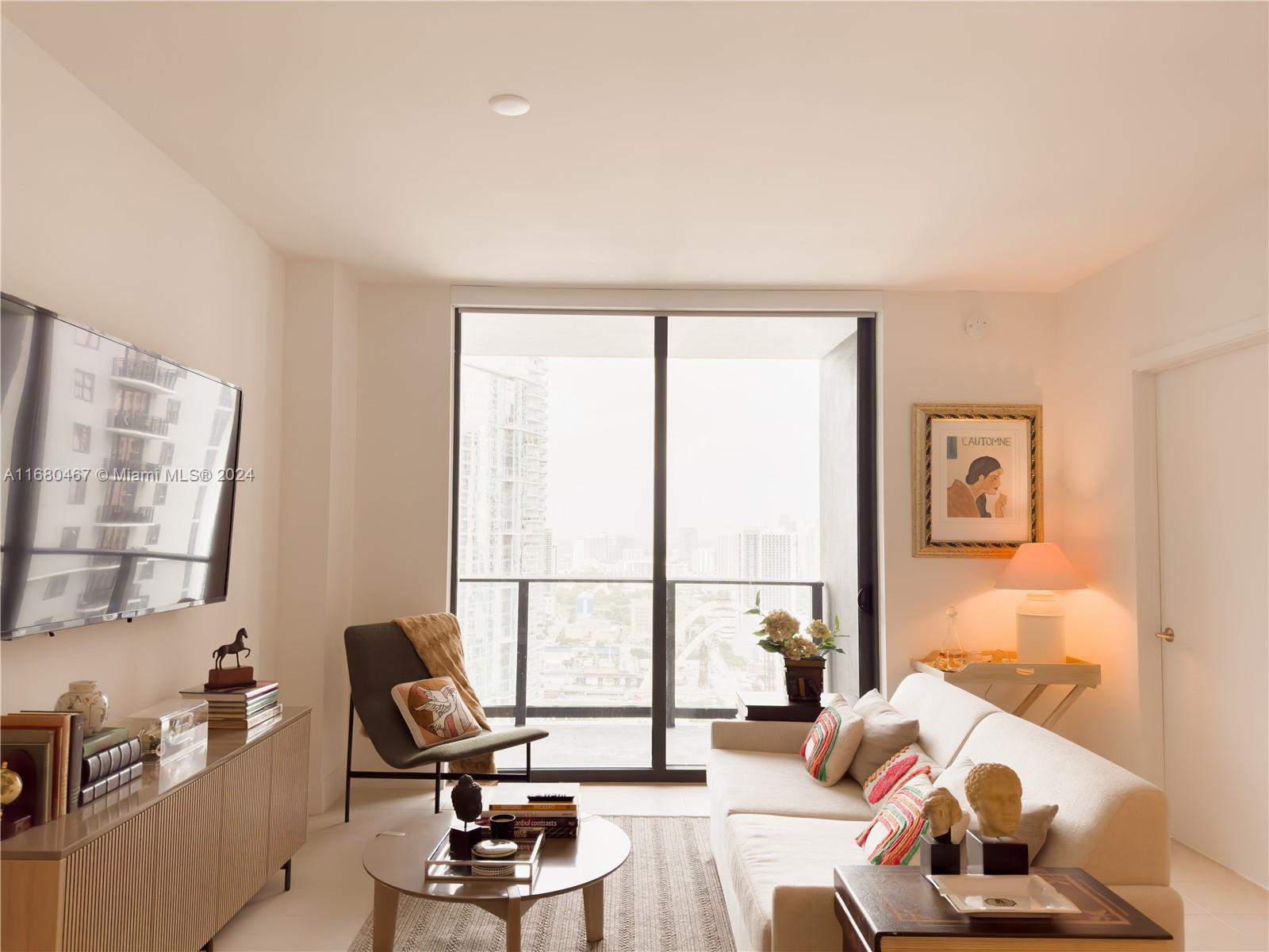 a living room with furniture and floor to ceiling windows