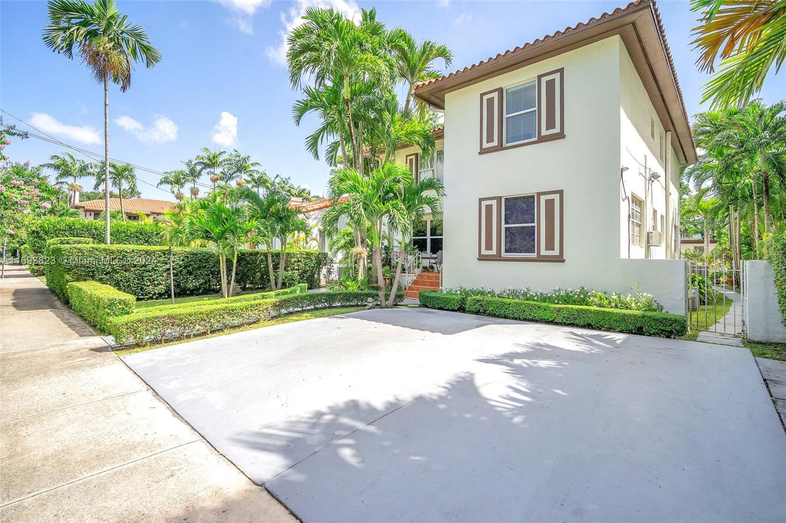 a view of a house with a yard and potted plants