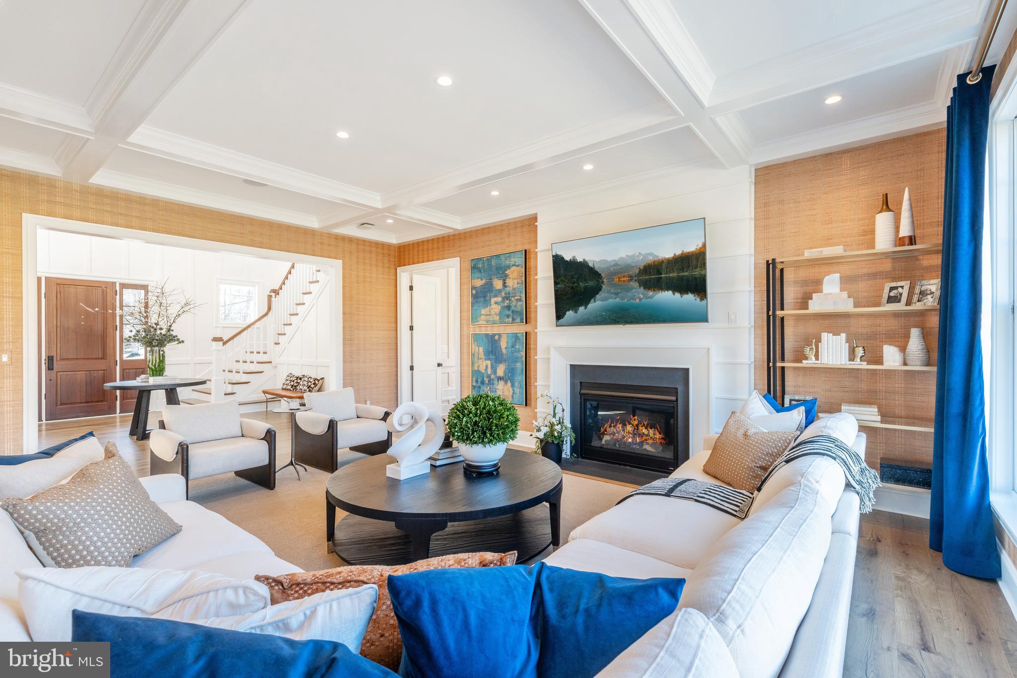 a living room with furniture fireplace and a large window