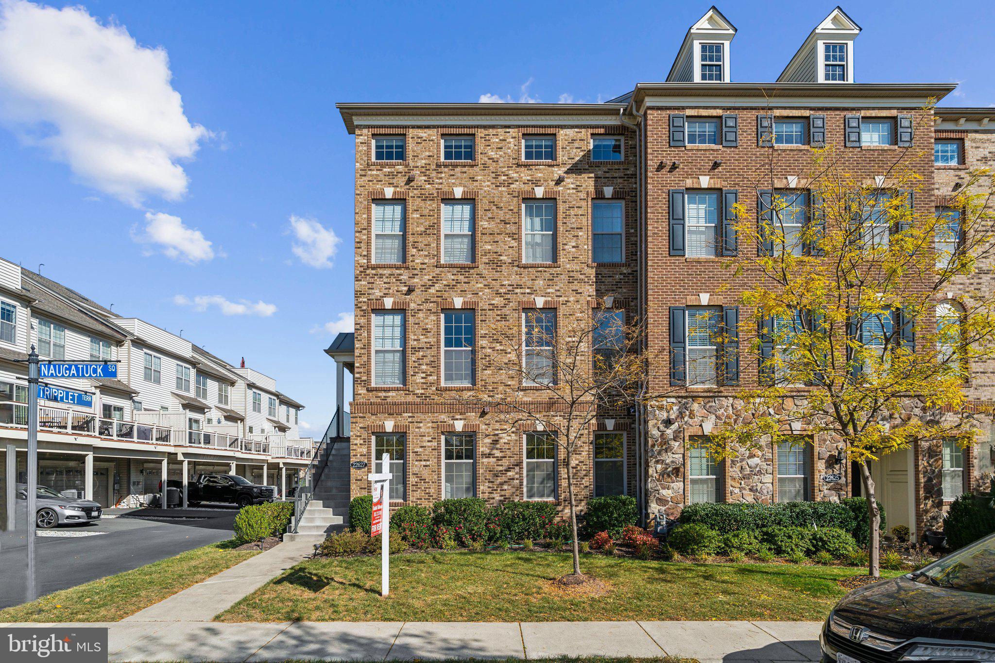 a front view of a residential apartment building with a yard