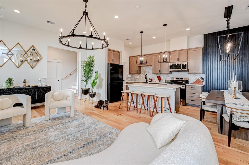 a living room with furniture kitchen view and a chandelier