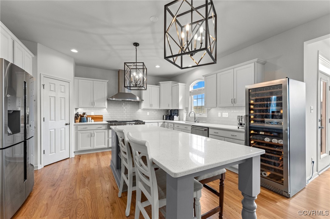 a kitchen with stainless steel appliances a table chairs microwave and cabinets