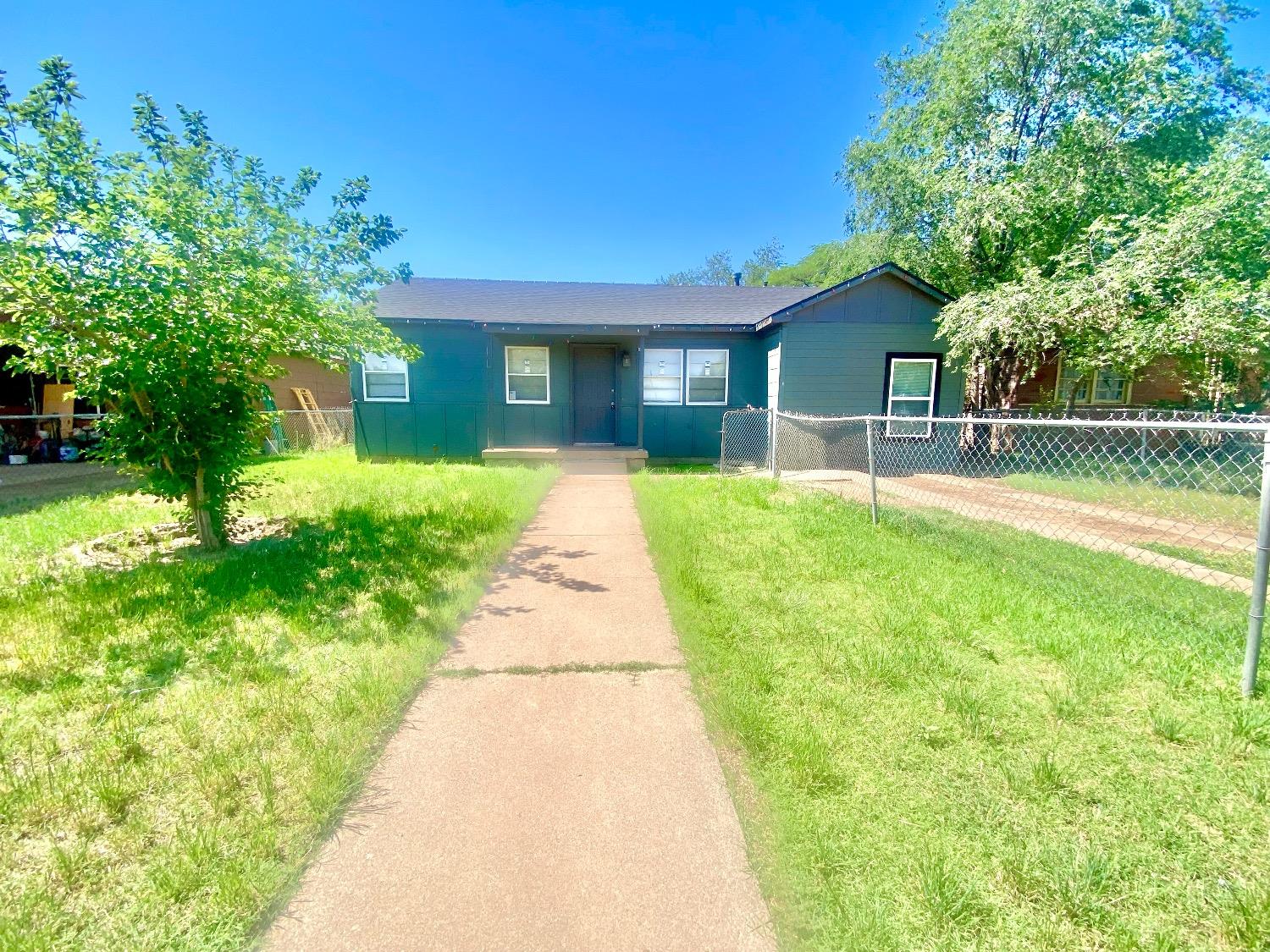 a front view of a house with a yard and trees