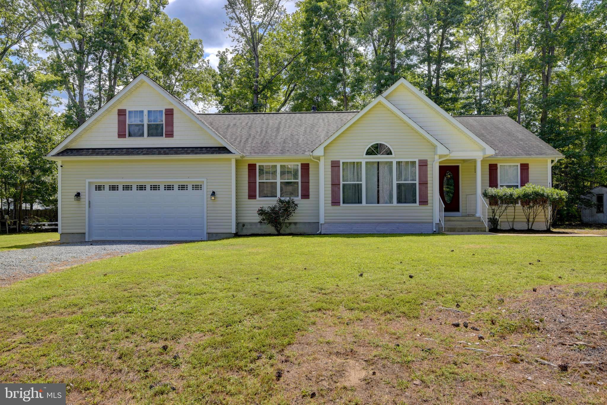 a front view of a house with a garden and yard