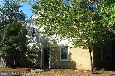 a front view of a house with a tree