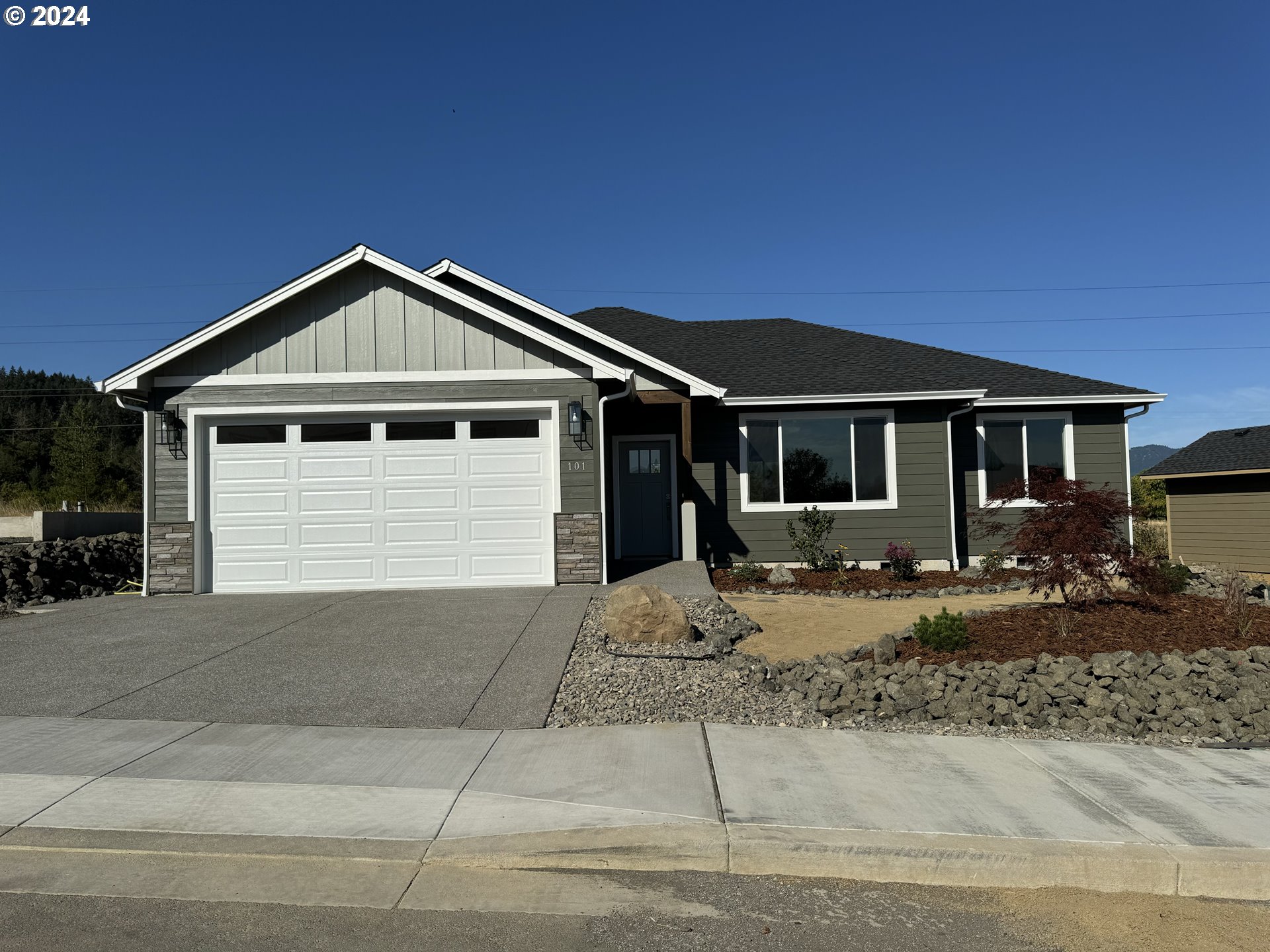 a front view of a house with yard and parking space