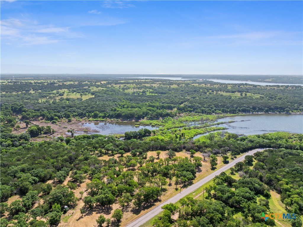 an aerial view of field with trees in background